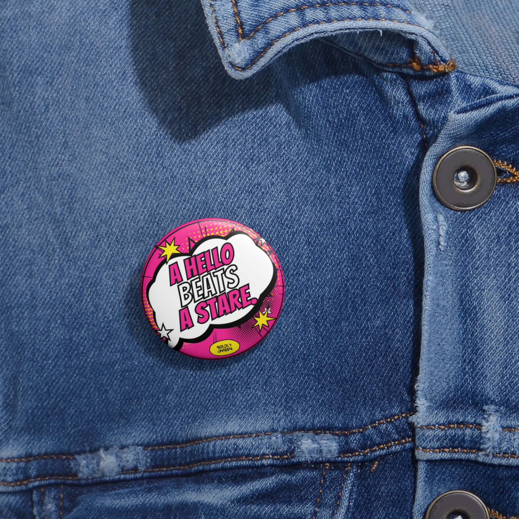 The smallest A Hello Beats a Stare. pin badge pinned on a denim jacket
