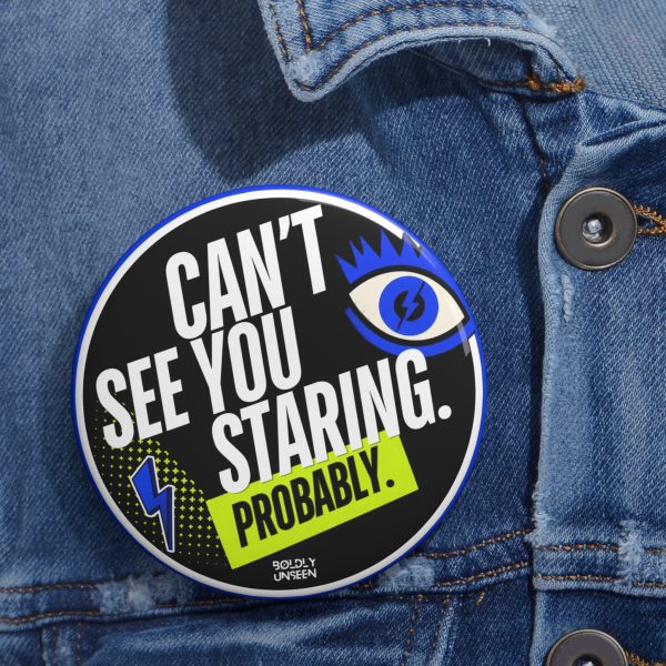 Can’t See You Staring. Probably. pin badge pinned on a blue denim jacket, black face, blue eye graphic, yellow Probably label